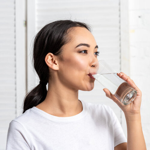 Young woman drinking a glass of water.